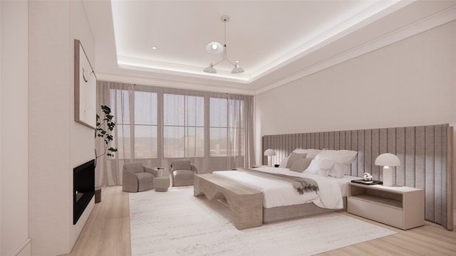 bedroom with light hardwood / wood-style flooring and a raised ceiling