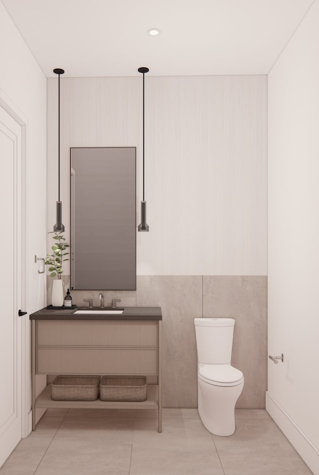 bathroom featuring tile walls, tile patterned floors, toilet, and sink