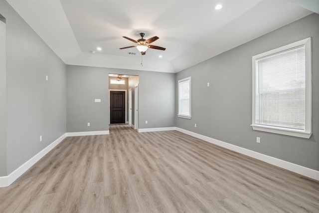 spare room with light wood-type flooring, ceiling fan, and plenty of natural light