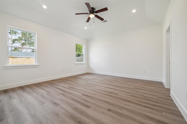 empty room with light wood-type flooring, vaulted ceiling, and ceiling fan