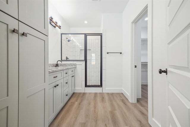 bathroom featuring wood-type flooring, vanity, and an enclosed shower