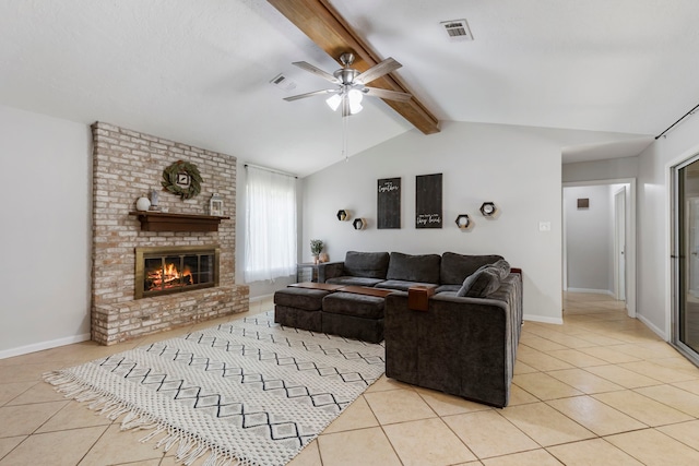 living room with light tile patterned flooring, ceiling fan, vaulted ceiling with beams, brick wall, and a brick fireplace