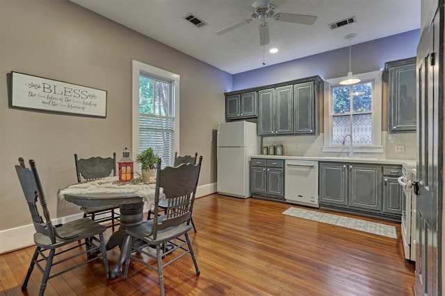 kitchen with white appliances, gray cabinetry, hardwood / wood-style floors, decorative light fixtures, and ceiling fan