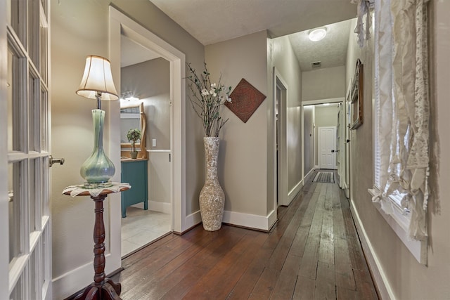 hallway featuring hardwood / wood-style flooring and a textured ceiling