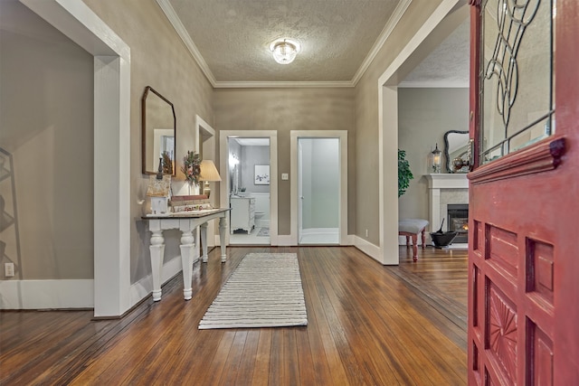 foyer entrance with dark wood-type flooring, a textured ceiling, and ornamental molding