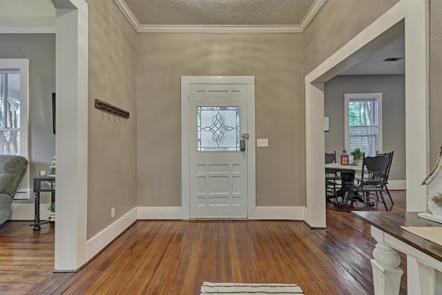 foyer entrance featuring ornamental molding, a textured ceiling, and hardwood / wood-style flooring