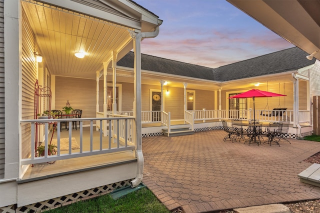 patio terrace at dusk featuring a porch