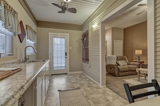 entryway with ornamental molding, sink, light tile patterned floors, and ceiling fan