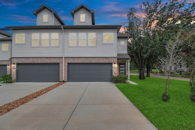 view of front of house featuring a garage and a lawn