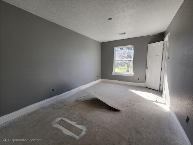 spare room with visible vents, a textured ceiling, and baseboards