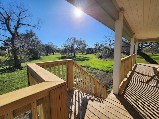 wooden terrace featuring a lawn