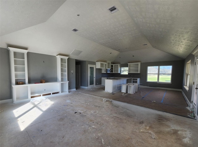 unfurnished living room featuring lofted ceiling, a textured ceiling, visible vents, and baseboards