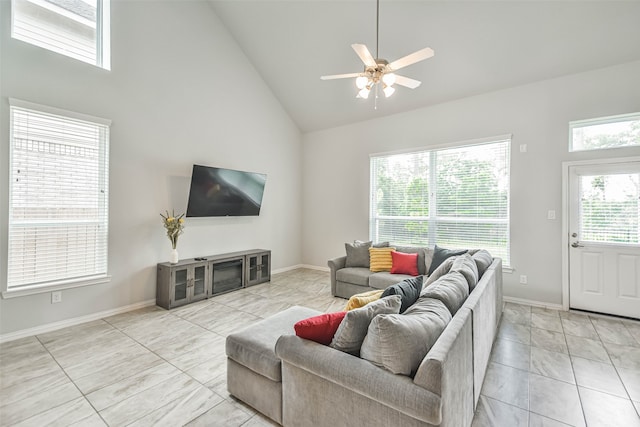 tiled living room with high vaulted ceiling, ceiling fan, and a wealth of natural light