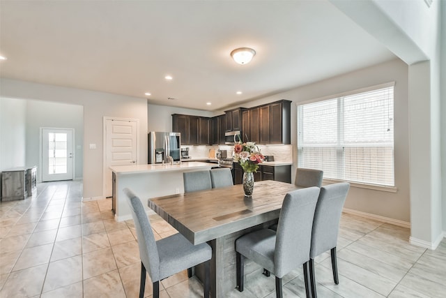 dining space with plenty of natural light, sink, and light tile patterned floors