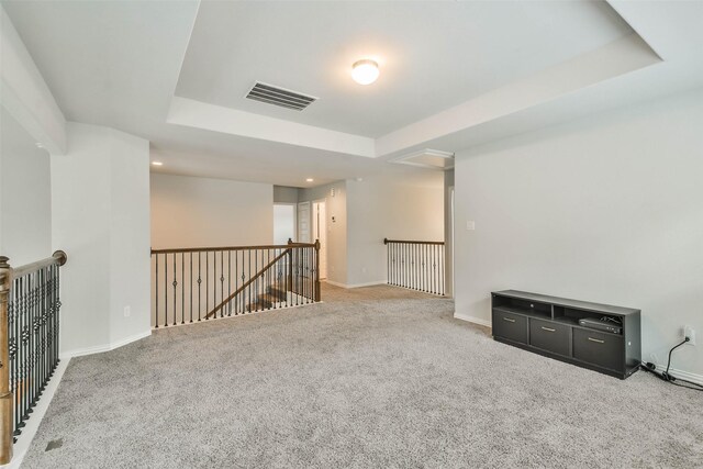 carpeted spare room with a tray ceiling