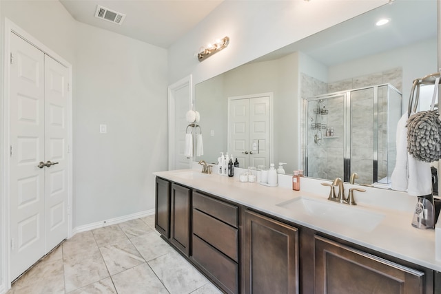 bathroom with tile patterned floors, walk in shower, and dual bowl vanity