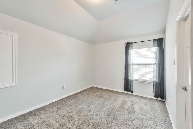 carpeted spare room with lofted ceiling