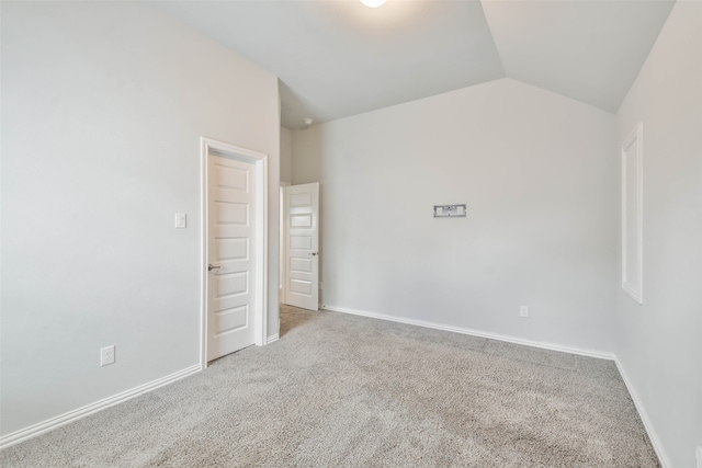 empty room with carpet floors and lofted ceiling