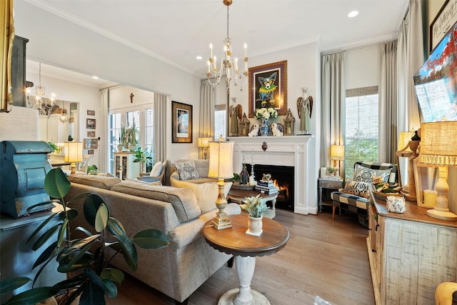 living room with ornamental molding, plenty of natural light, light hardwood / wood-style floors, and a chandelier