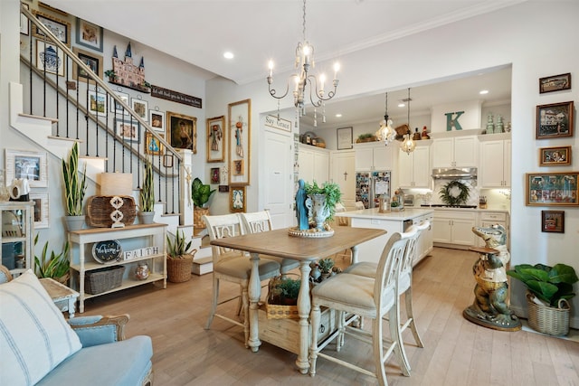 dining room featuring an inviting chandelier, crown molding, and light wood-type flooring