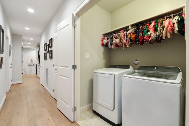 laundry room featuring washer and dryer and light wood-type flooring