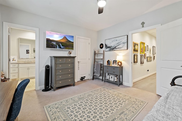 bedroom with light colored carpet, ceiling fan, and ensuite bathroom