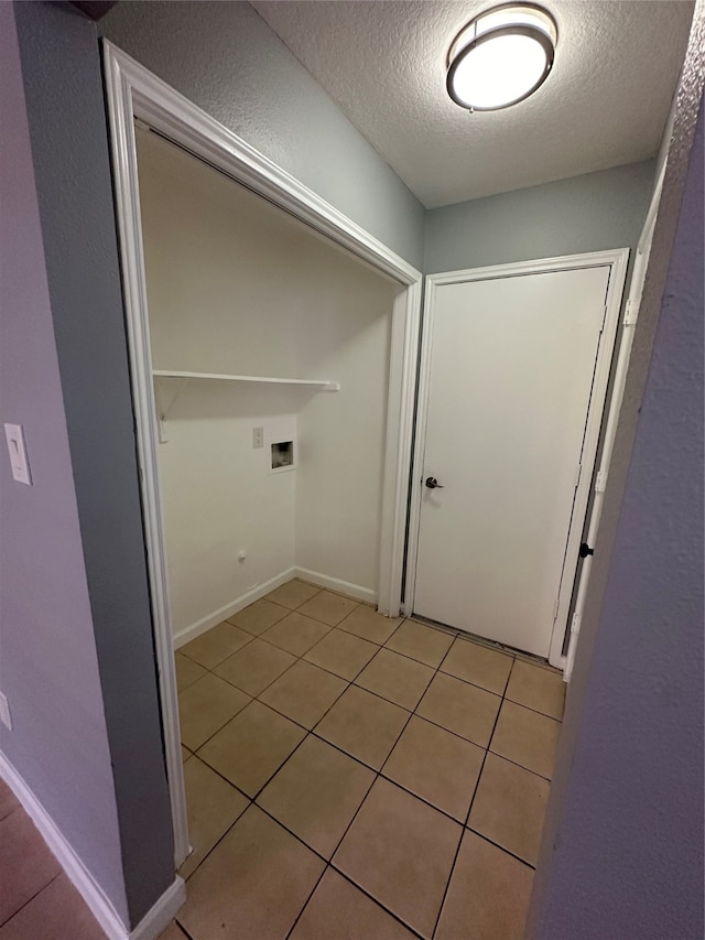 corridor with light tile patterned floors and a textured ceiling