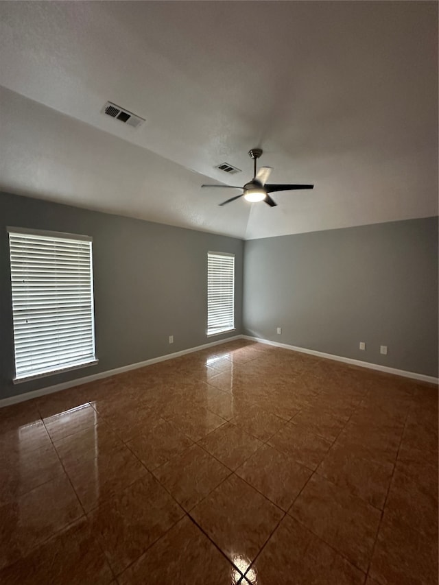 tiled spare room featuring ceiling fan