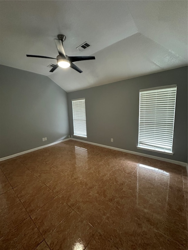 spare room featuring tile patterned flooring, vaulted ceiling, and ceiling fan