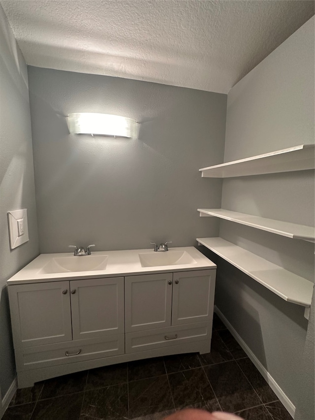 bathroom with vanity, a textured ceiling, and tile patterned floors