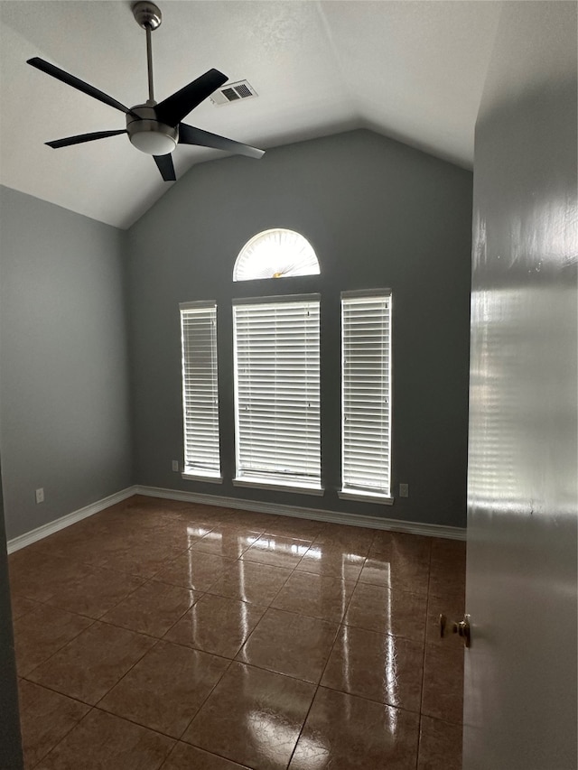 spare room with tile patterned floors, vaulted ceiling, and ceiling fan