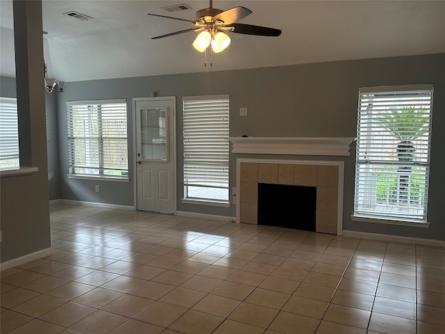 unfurnished living room with a fireplace, ceiling fan, lofted ceiling, and light tile patterned floors