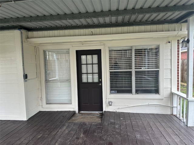 view of exterior entry featuring a wooden deck