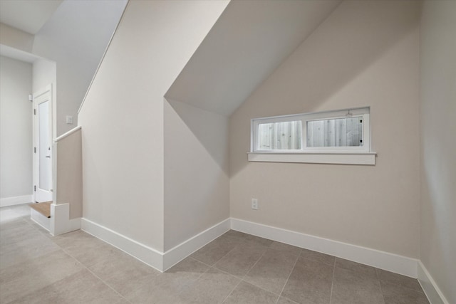 bonus room with vaulted ceiling and light tile patterned floors