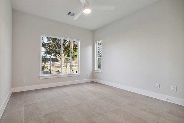 tiled spare room featuring ceiling fan