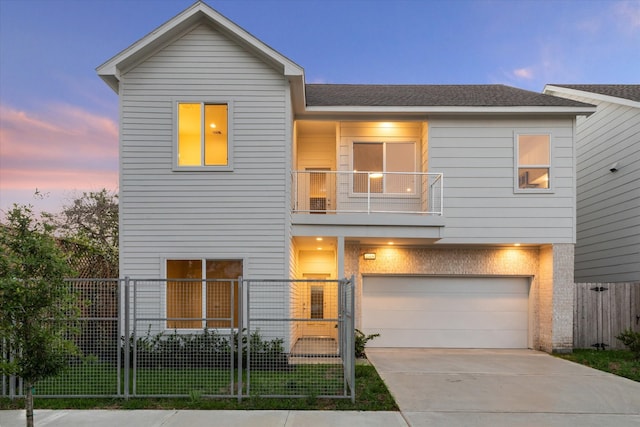 view of front of property featuring a balcony, a garage, and a yard