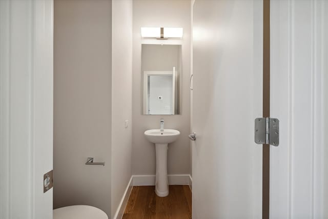 bathroom with wood-type flooring and toilet