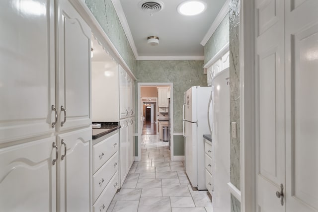 interior space with crown molding, vanity, and tile patterned flooring