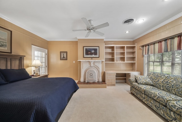 carpeted bedroom with ceiling fan, a fireplace, multiple windows, and ornamental molding