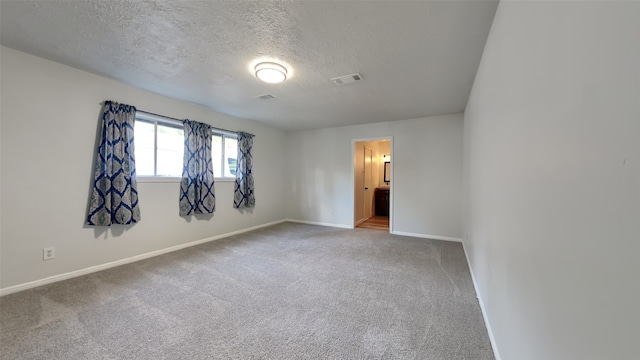 carpeted spare room with a textured ceiling