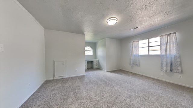 unfurnished room with carpet, a wealth of natural light, and a textured ceiling