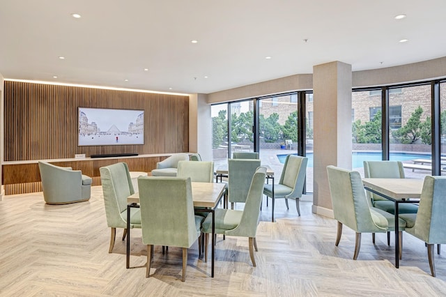 dining space featuring wooden walls and light parquet floors