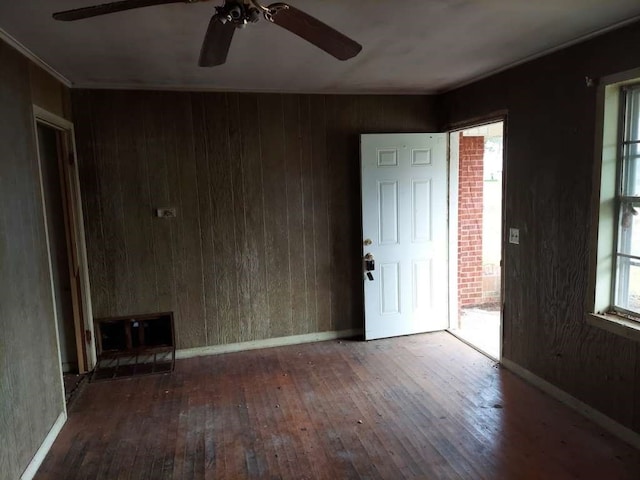 spare room featuring brick wall, ceiling fan, and wood-type flooring