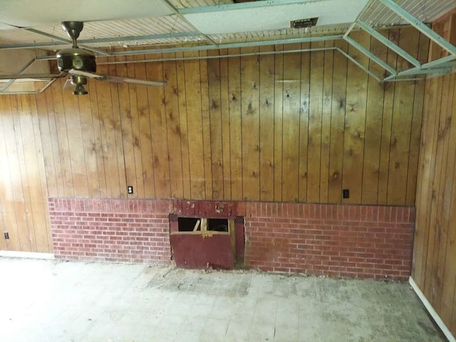 interior space with wooden walls and ceiling fan