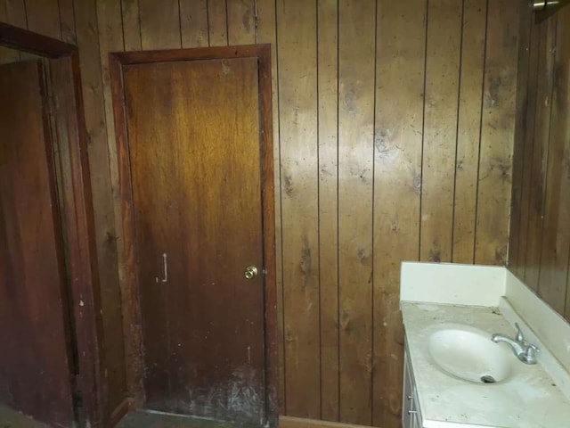 bathroom featuring vanity and wooden walls