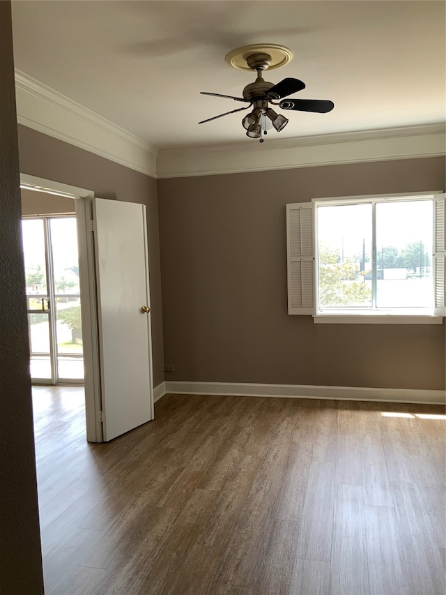 spare room with ceiling fan, wood-type flooring, crown molding, and plenty of natural light