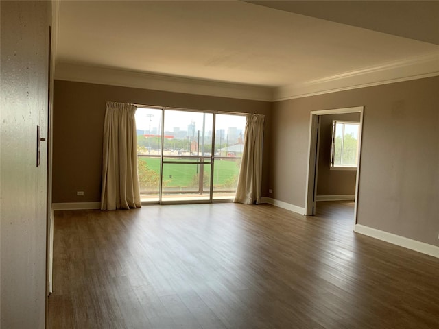 unfurnished room featuring ornamental molding, dark wood-style flooring, and baseboards