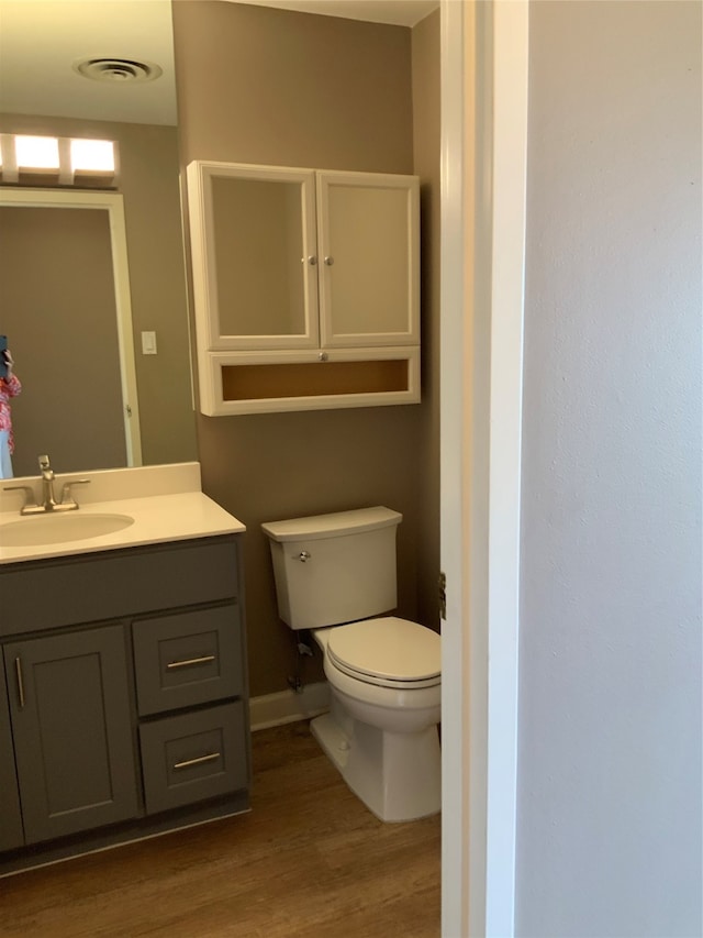 bathroom featuring vanity, toilet, and hardwood / wood-style flooring