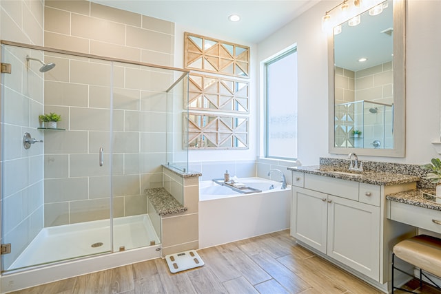 bathroom with plenty of natural light, vanity, shower with separate bathtub, and wood-type flooring