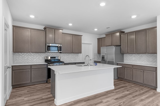 kitchen featuring sink, appliances with stainless steel finishes, light hardwood / wood-style flooring, and backsplash